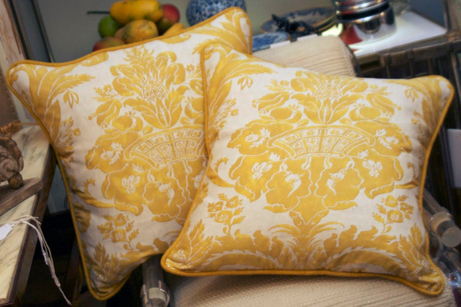 A pair of 50’s Fortuny fabric cushions yellow with pomegranate motif on gold ground and braid trim.