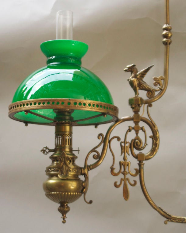 A French bronze billiard fixture with arched horizontal frame suspended from chain and canopy, the Neo-Grec design featuring 2 oil burners having round pierced rims securing glass half dome. The frame detailed with Classical motifs.