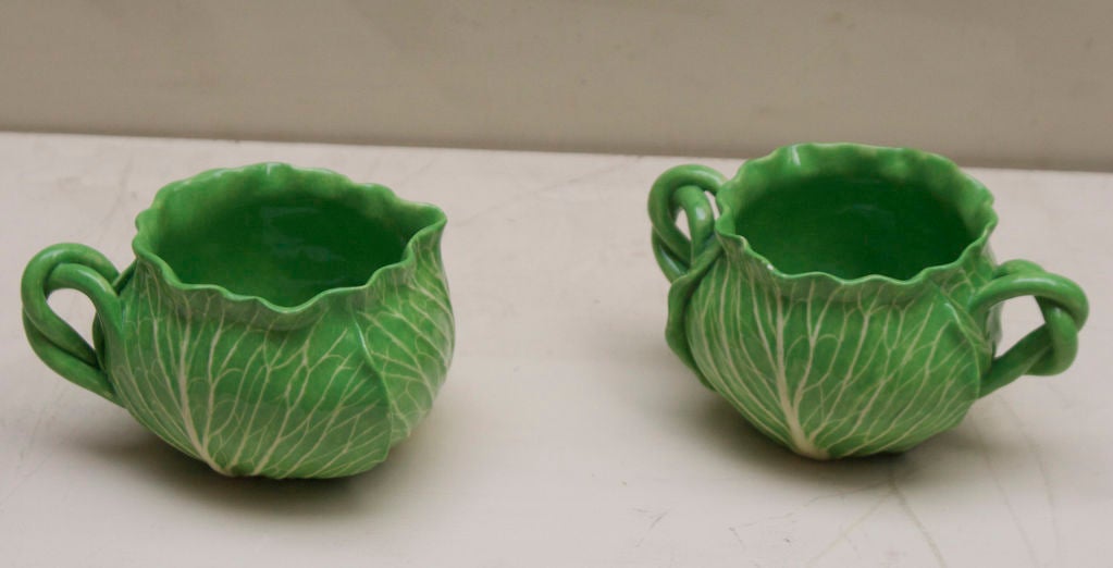 A pair of Faience lettuce leaf soft paste porcelain pieces comprised of a sugar and a creamer, retailed by the Palm Beach store “Au Bon Gout” designed by Dodi Thayer.

Sugar and Creamer, 3” Height