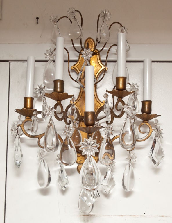 A pair of gilt bronze French Louis XV style five-light wall sconces with crystal drops.