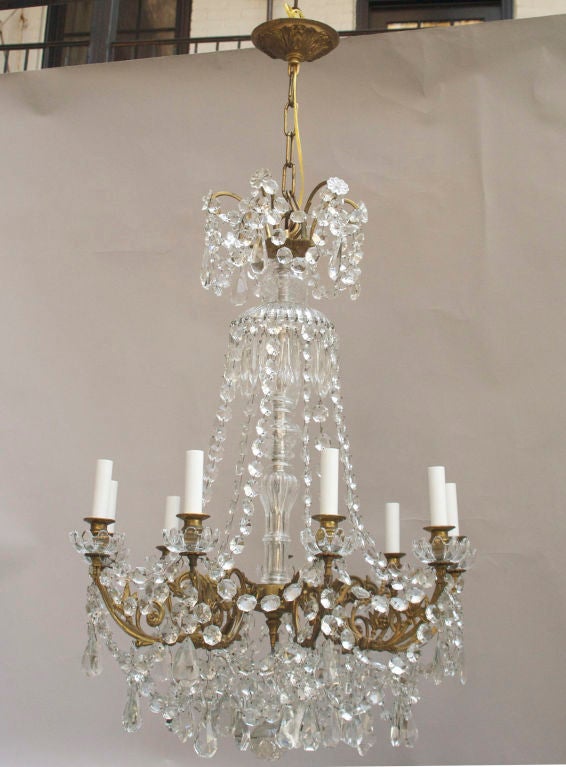 A 9 light French baccarat chandelier, the Louis XV designed gilt bronze frame draped with faceted crystal beads and baccarat crystal drops. The center stem covered with vase and ball shaped crystal elements below umbrella shaped crystal elements