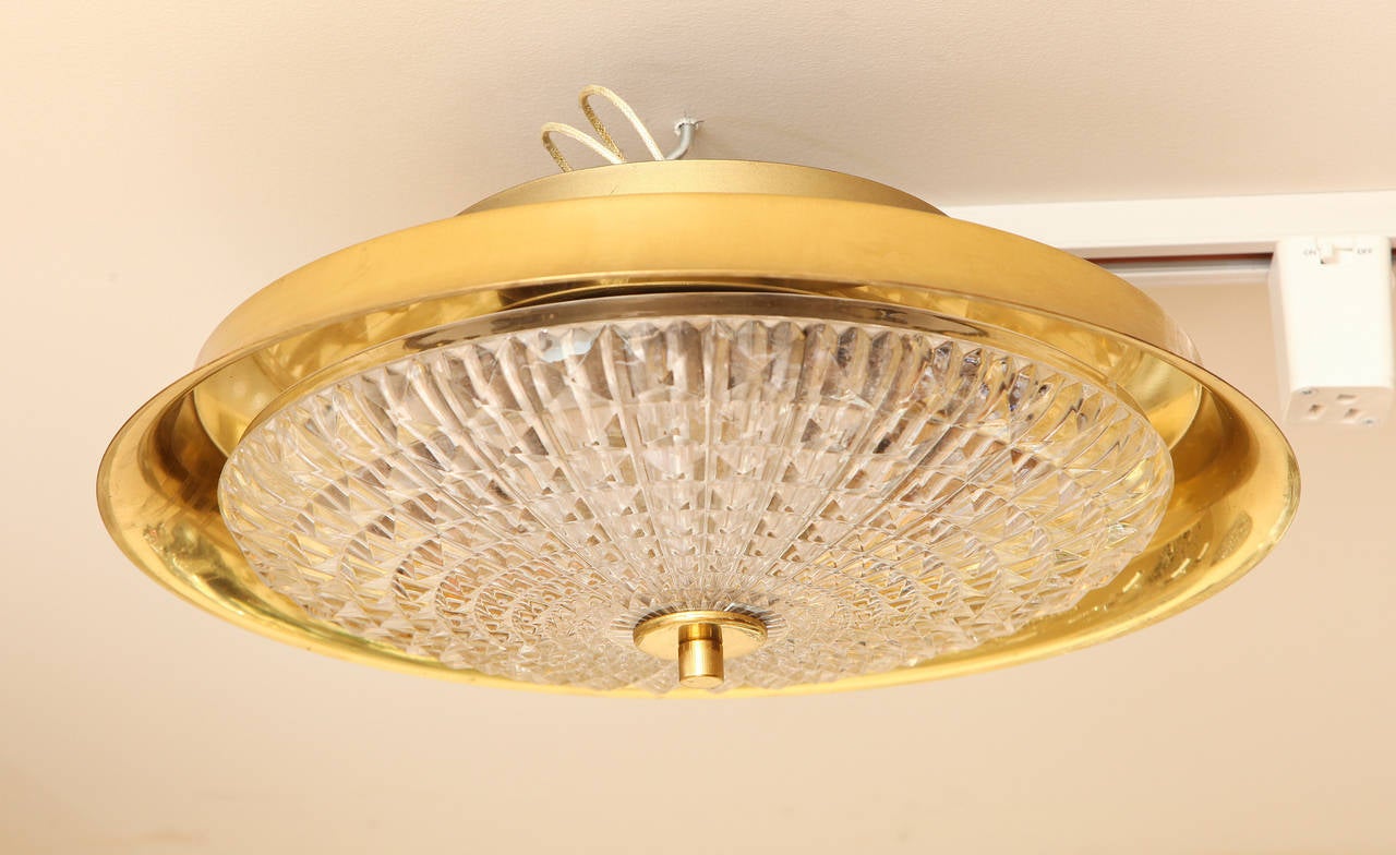 A Swedish Orrefors flush mount light fixture designed by Carl Fagerlund with textured glass dish concealing 5 sockets and having polished brass domed cover.