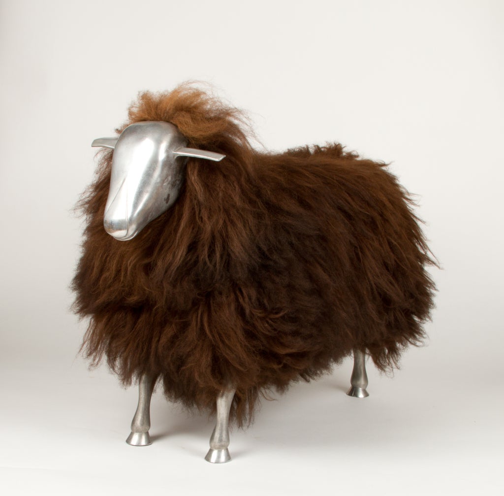 A cast steel sheep with stylized head and hooved feet, the wooden body covered in lamb fur. In the manner of Claude LaLanne.
