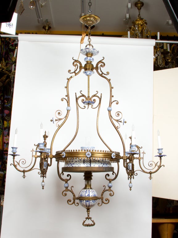 A seven light horizontal Dutch oil powered suspension chandelier now stationary, the center frame bracketed by a set of candle arms on either side the center with large blue and white Delft dome and oil font.