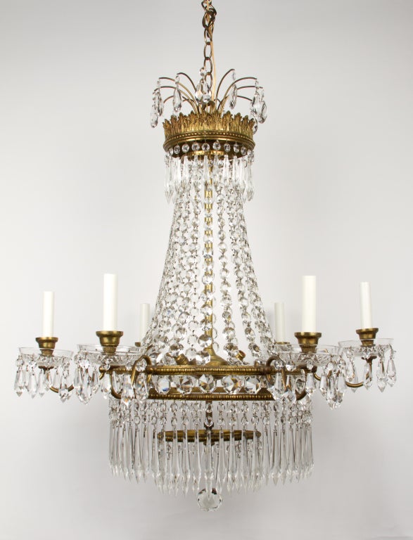 An English Regency style waterfall chandelier with gilt bronze frame, the crown shaped top with facetted beads of graduated size draped to round frame having inset beads and issuing 6 candle arms.
