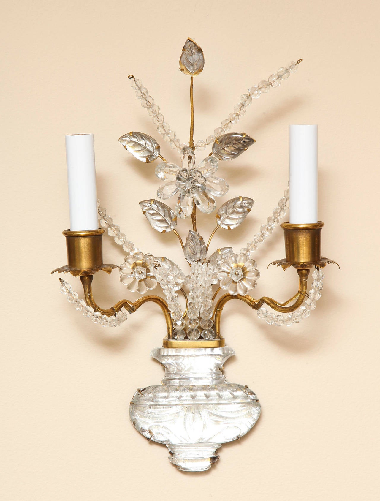 A pair of two light Bagues style bronze wall lights with handmade sprays of crystal beads forming branches and flowers. Each bobeche with hand cut leaf form cup on underside. The arms issuing from carved glass vase shaped element. By American maker