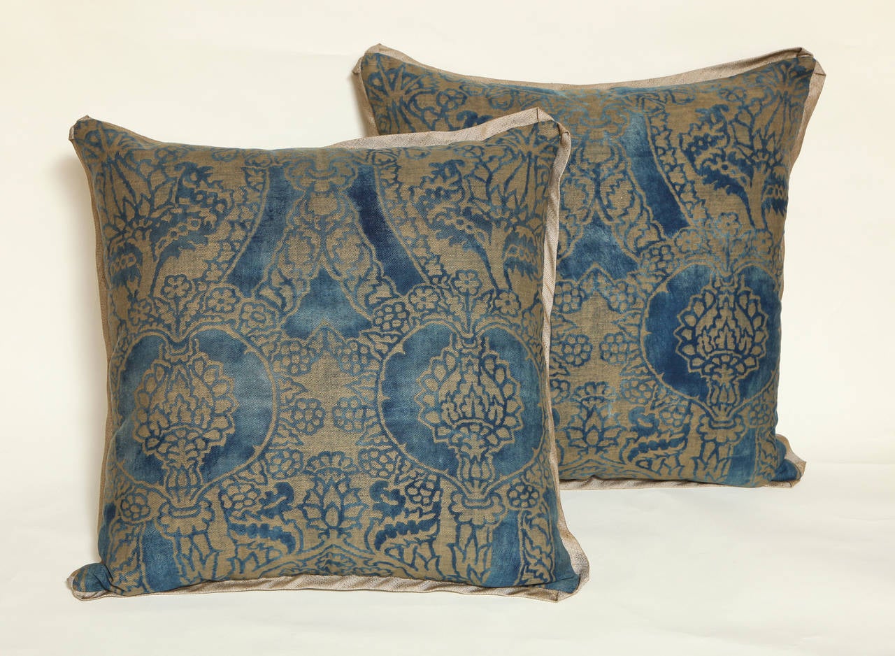 A pair of vintage Fortuny fabric cushions in the Nicolo pattern, in a blue and silvery gold colorway with metallic woven silk bias edging and matching backs, the pattern, a 15th century Renaissance design with pomegranate motif.
Fabric printed at