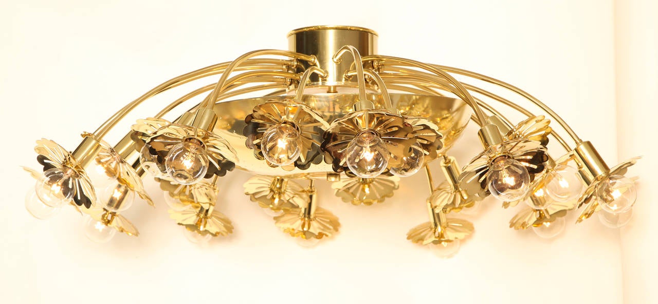 A pair of ceiling mounted 24 light fixture with pierced brass dome issuing downswept candle arms with oversized rosette shaped bobeches. Attributed to Paavo Tynell. (Can be sold individually).