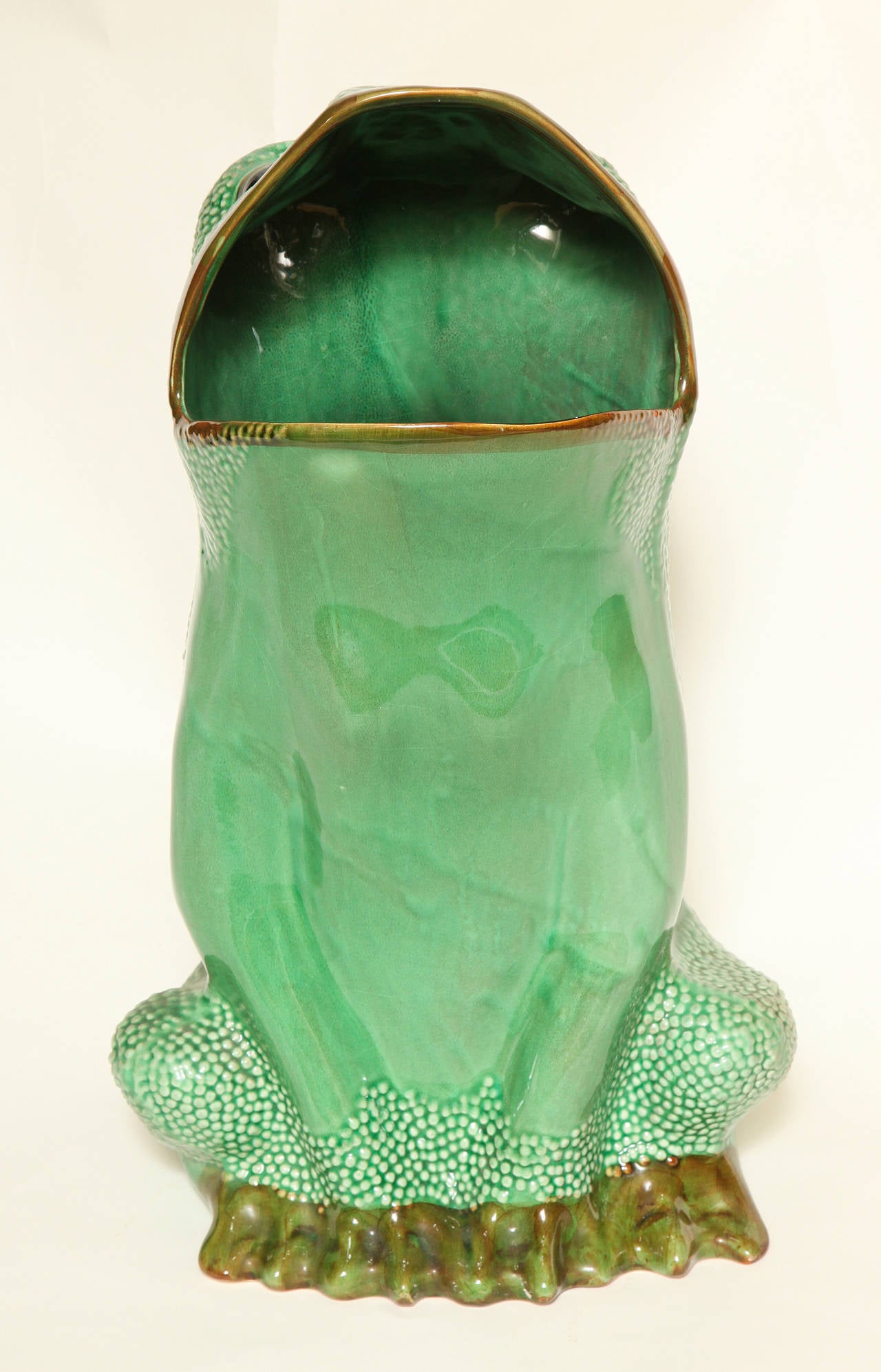 An Italian ceramic frog umbrella stand. The naturalistic form seated and with an open mouth designed to hold umbrellas. Stamped with San Francisco retailer Gump's mark.