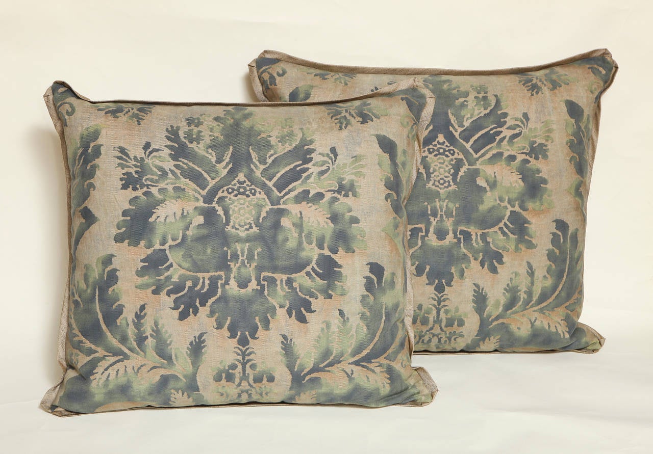 A pair of Fortuny fabric cushions in the Glicine pattern, green/grey color way with Rogers and Goffigon linen/silk blend bias edging and matching backs, the pattern, a 17th century Italian design with Wisteria motif 
50 down/50 feather insert. 

 
