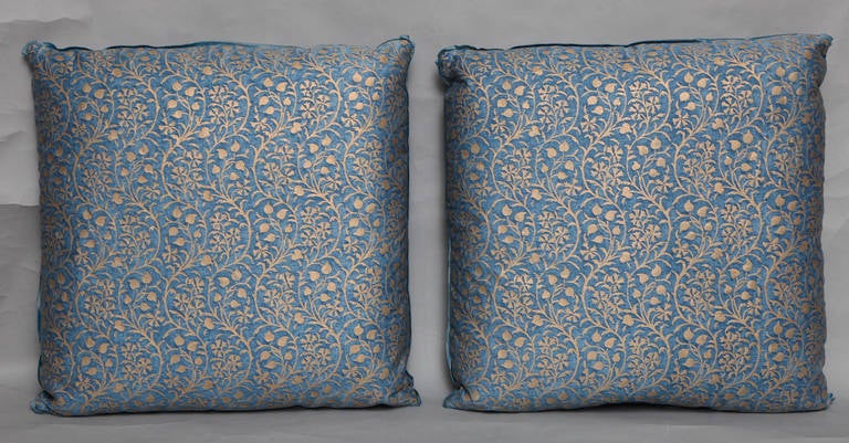 A pair of Fortuny fabric cushions in the Granada pattern, blue and silvery gold colorway with metallic silk backing and bias edging, the pattern, a modern Spanish design named for the birthplace of Mariano Fortuny in Granda, Spain 
50 down/50