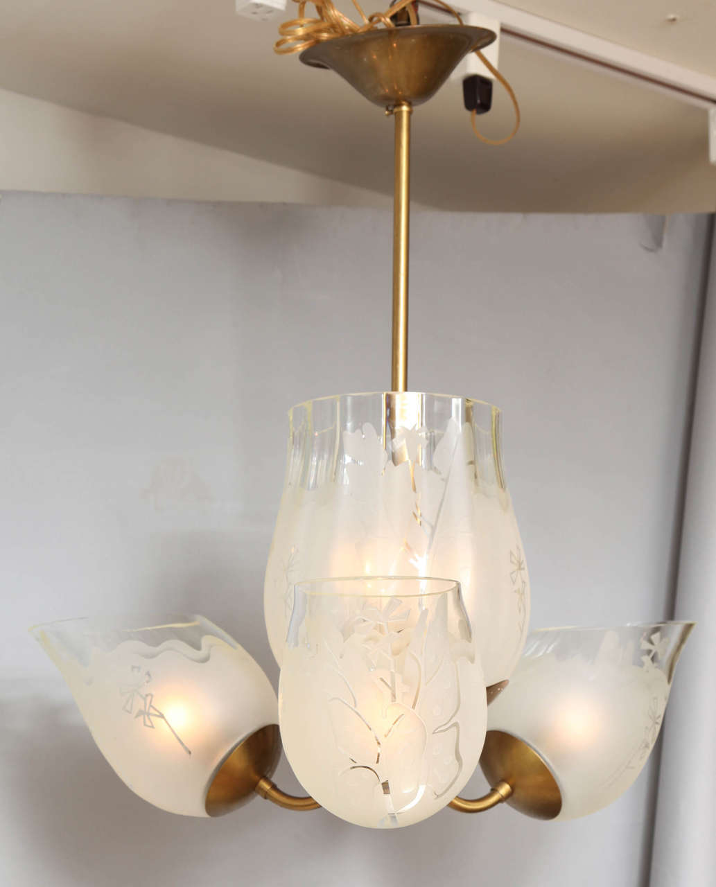 A Swedish 4-light ceiling fixture with vase shaped etched glass center, having perforated brass rosette on underside and issuing three tulip shaped globes at a 45 degree angle. Signed by maker Glossner.