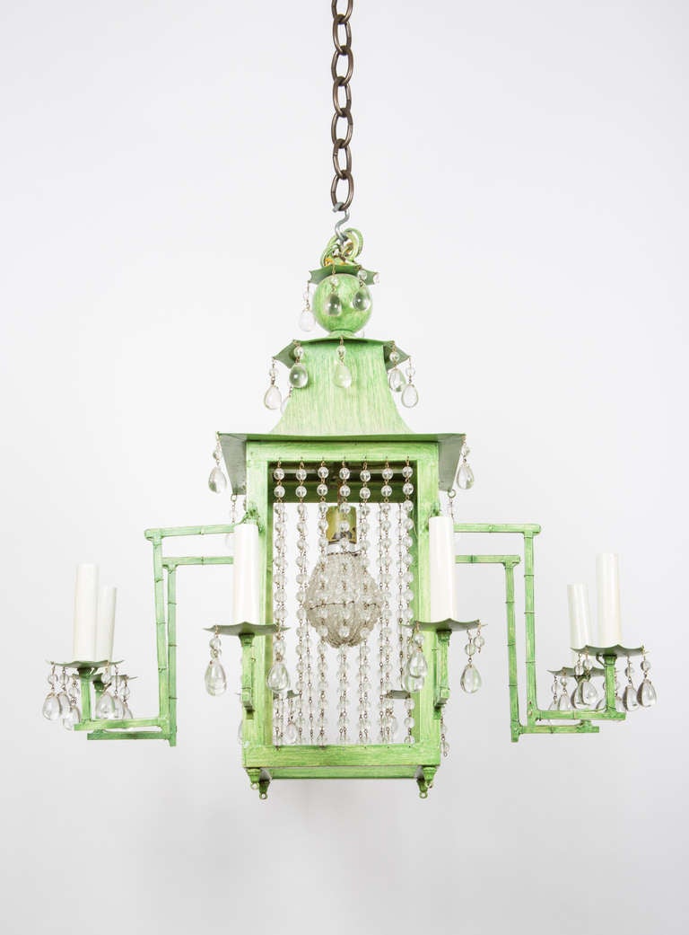 A new, eight light Chinoiserie design tole chandelier, the pagoda shaped center with strands of crystal beads concealing center socket and with strie painted finish. Six- to eight-week lead time.