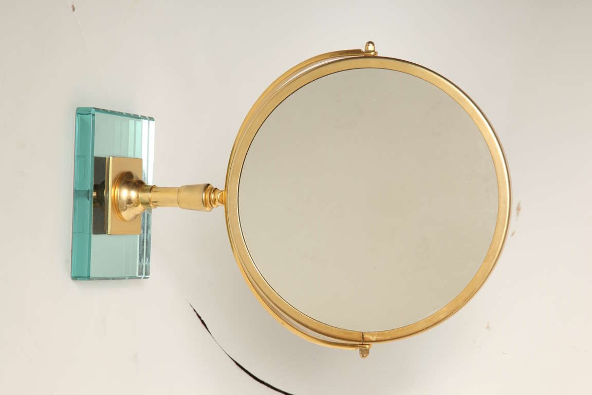A Round Gilt Metal Magnifying Mirror pivoting on stand with plain mirror on stand with square glass base signed by French maker Miroir Brot.