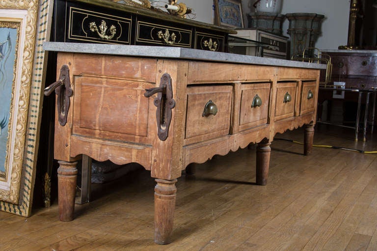 A 4 drawer low table with raised panel doors, each with butlers pulls above scalloped edge base supported by 6 round turned legs and having limestone top.