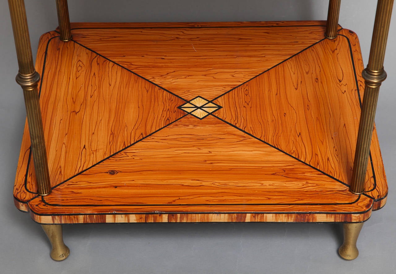 A two tiered English Regency style side table. The square wooden surfaces painted with faux bois finish having marquetry stringing and cross banding detail. The center of the upper section with round medallion painted with seashells. Surfaces are