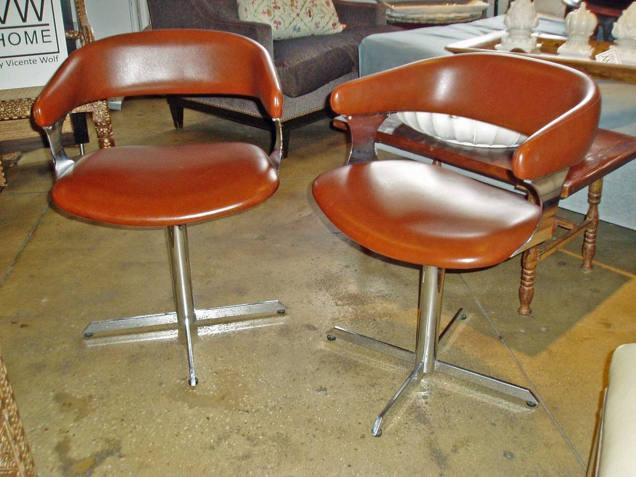 A pair of curved back, swivel armchairs from Paris, circa 1950's.  Priced and sold separately.