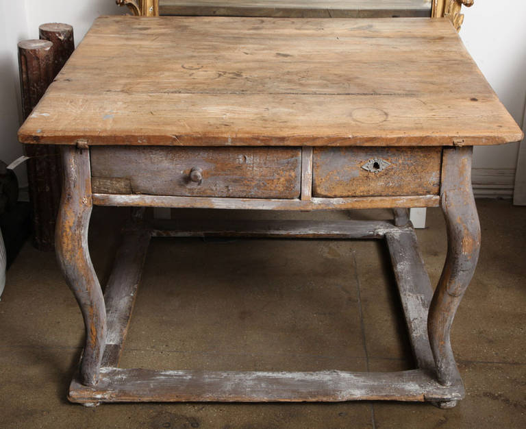 An antique table from Lyon, 19th century. With unfinished top and painted base, cabriole legs, two drawers, stretchers.