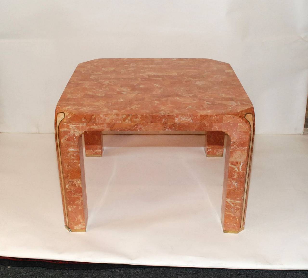 A stunning Karl Springer tessellated marble finish side table. Each leg is accented with a brass inlay. Karl Springer Ltd suede or leather label under the table.