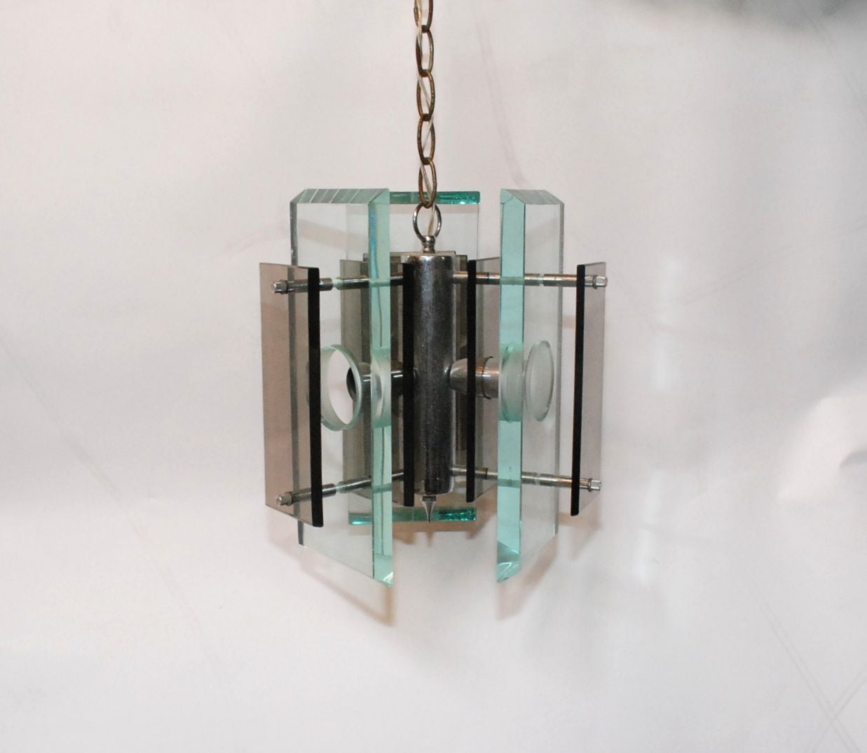 An elegant vintage Italian three-light chandelier in the manner of Fontana Arte. Fixture still has the European sockets but will be rewired to American standards when purchased (included in price). Made of chromed metal, green edged glass and dark
