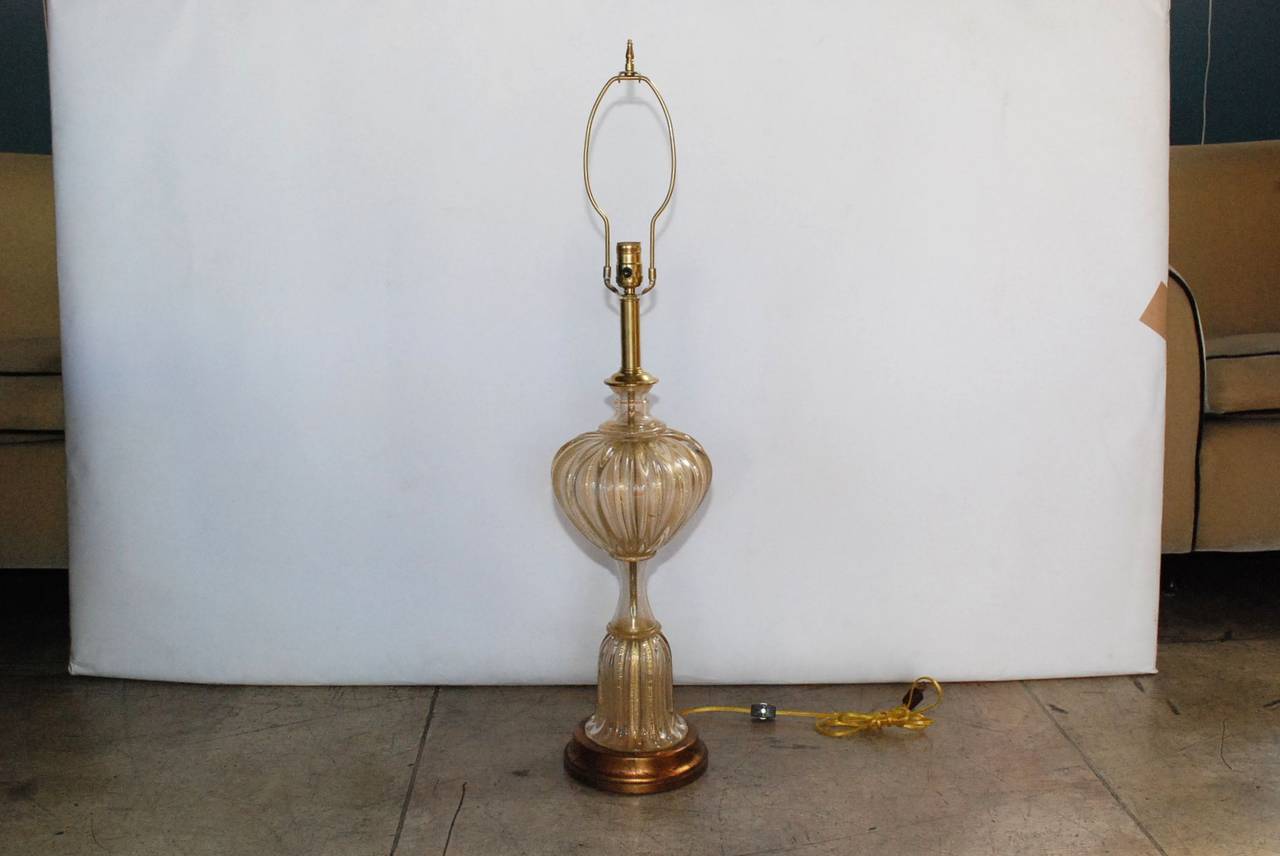 A gold infused Mid-Century Murano lamp by Barovier & Toso. Mounted on a gilded veined wood plinth base with brass hardware. Sold without a shade. Height is 38