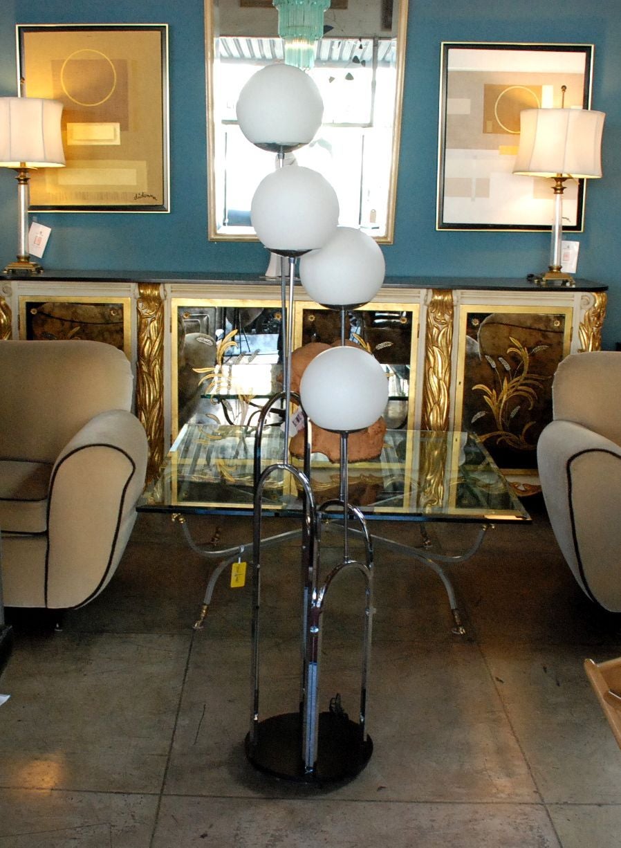 An attractive and well made Mid-Century Modern floor lamp in the manner of Milo Baughman. Made of chrome and frosted glass on a black wood base. Centre pole three-way switch allows you to turn on alternating sets of two lights or all four lights.