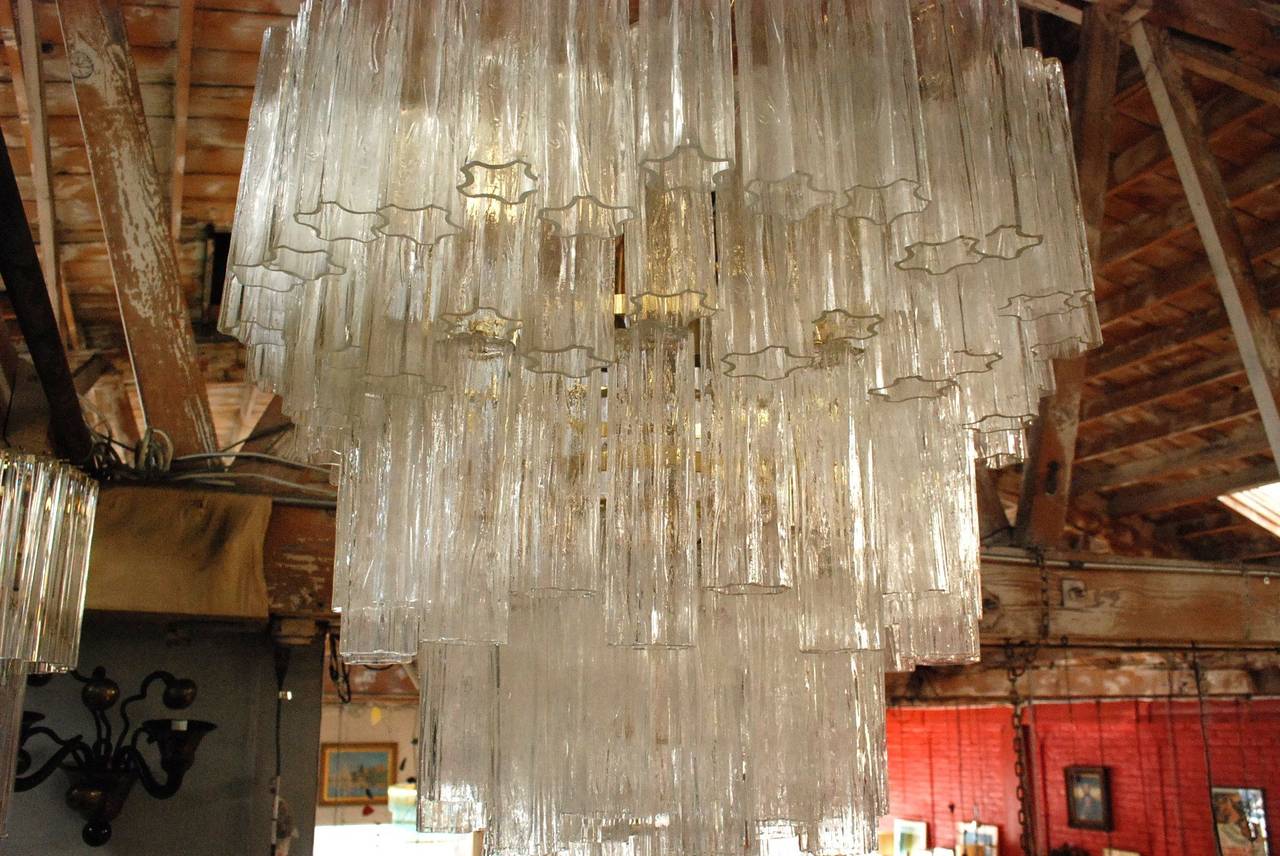 An outstanding clear Murano glass tronchi chandelier by Venini. Frame is in brass and has nine lights. There are 124 hanging glass tubes. Each one is star-shaped (see bottom photo). Dimensions are given for fixture only (without chain).