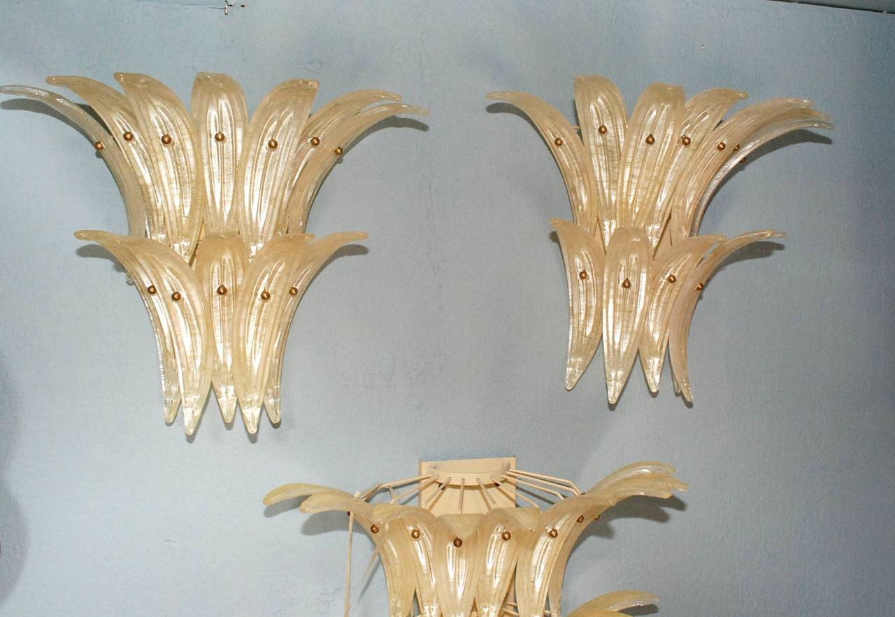 A beautiful pair of Barovier & Toso Palmette sconces. Each sconce has three lights and consists of two tiers of leaf forms. Accented with brass balls. Cream enameled hardware (backplates and hidden arms).