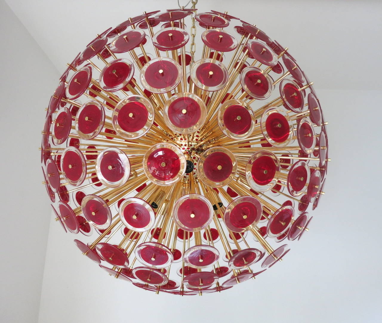 A fabulous Vistosi red Murano glass chandelier. Frame is polished brass with 16 regular light sockets. Chandelier is decorated with 207 red and clear glass discs for spectacular presentation. Size given is for fixture only (excludes chain and