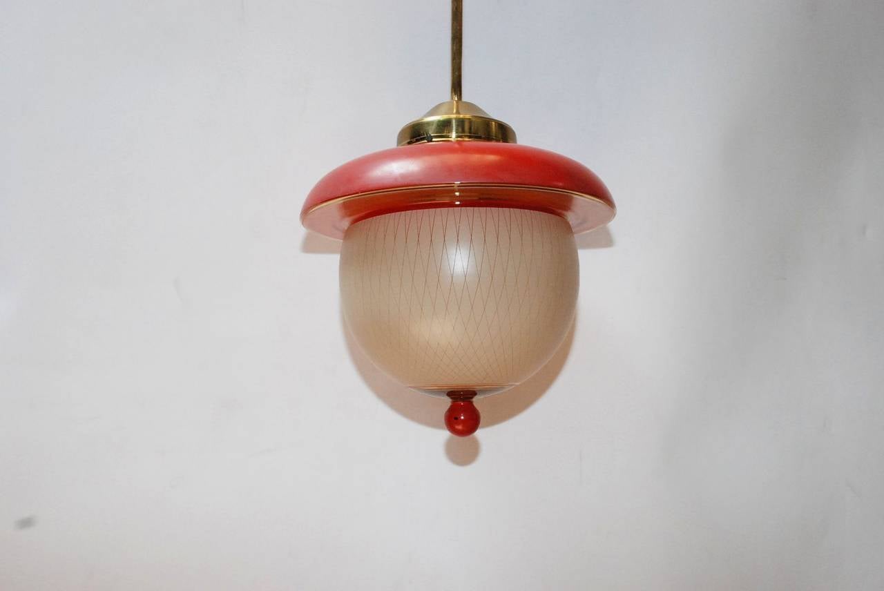 A red and cream Murano glass pendant by Stilnovo. Has one light and brass hardware. Height provided is to the top of the canopy.