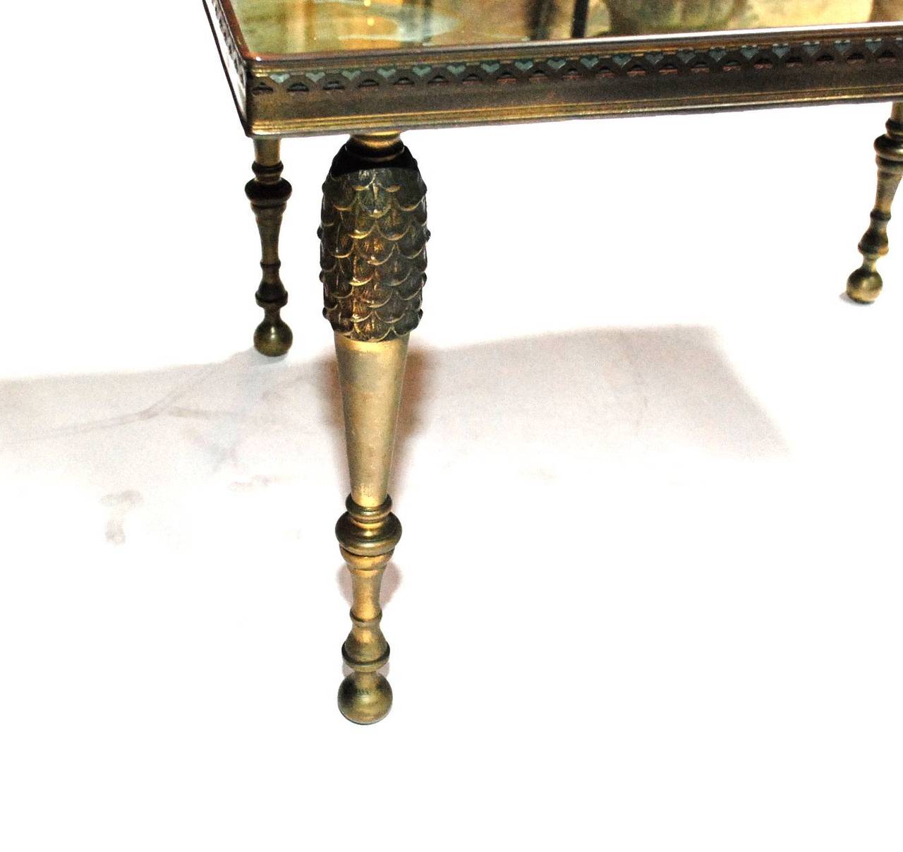 A pair of Hollywood Regency side tables with mirrored tops. Each table has a pierced gallery. Mirrored tops shows some age and have wear to the silvering.