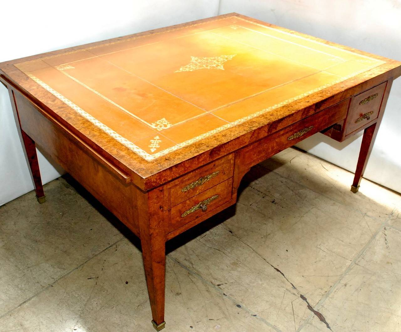 A 19th century French partners desk in the Directoire style.. Desk top and extension slides have a gold tooled leather top. There are five drawers on each side with bronze hardware. Each side has a 15