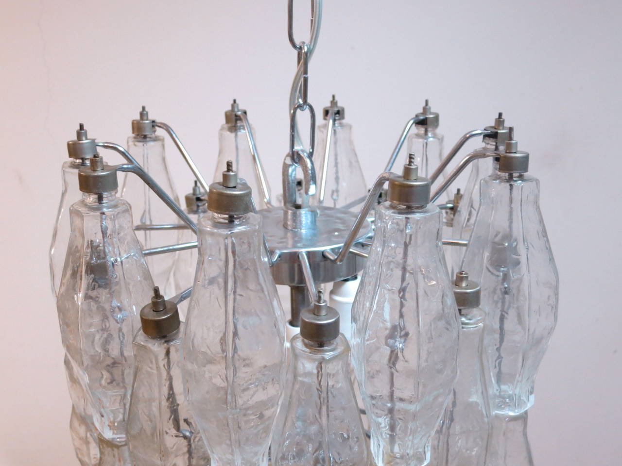 A polyhedral chandelier in the style of Venini. Has six lights and chrome hardware.