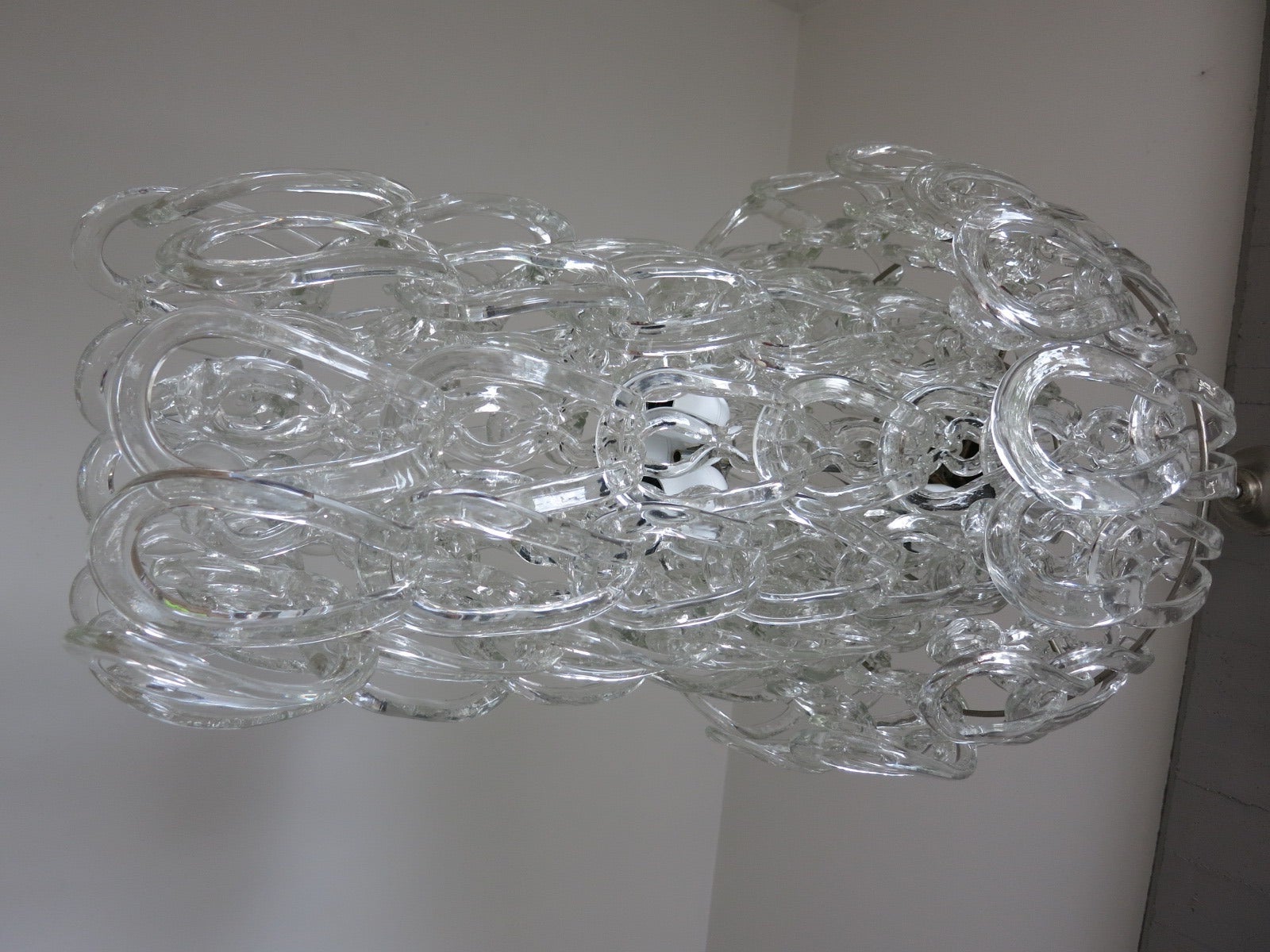 A vintage Vistosi links chandelier designed by Angelo Mangiarotti. The fixture has four lights and a chrome frame. There are a total of 84 Murano glass links. Measurements are for fixture only (chain and canopy extra).