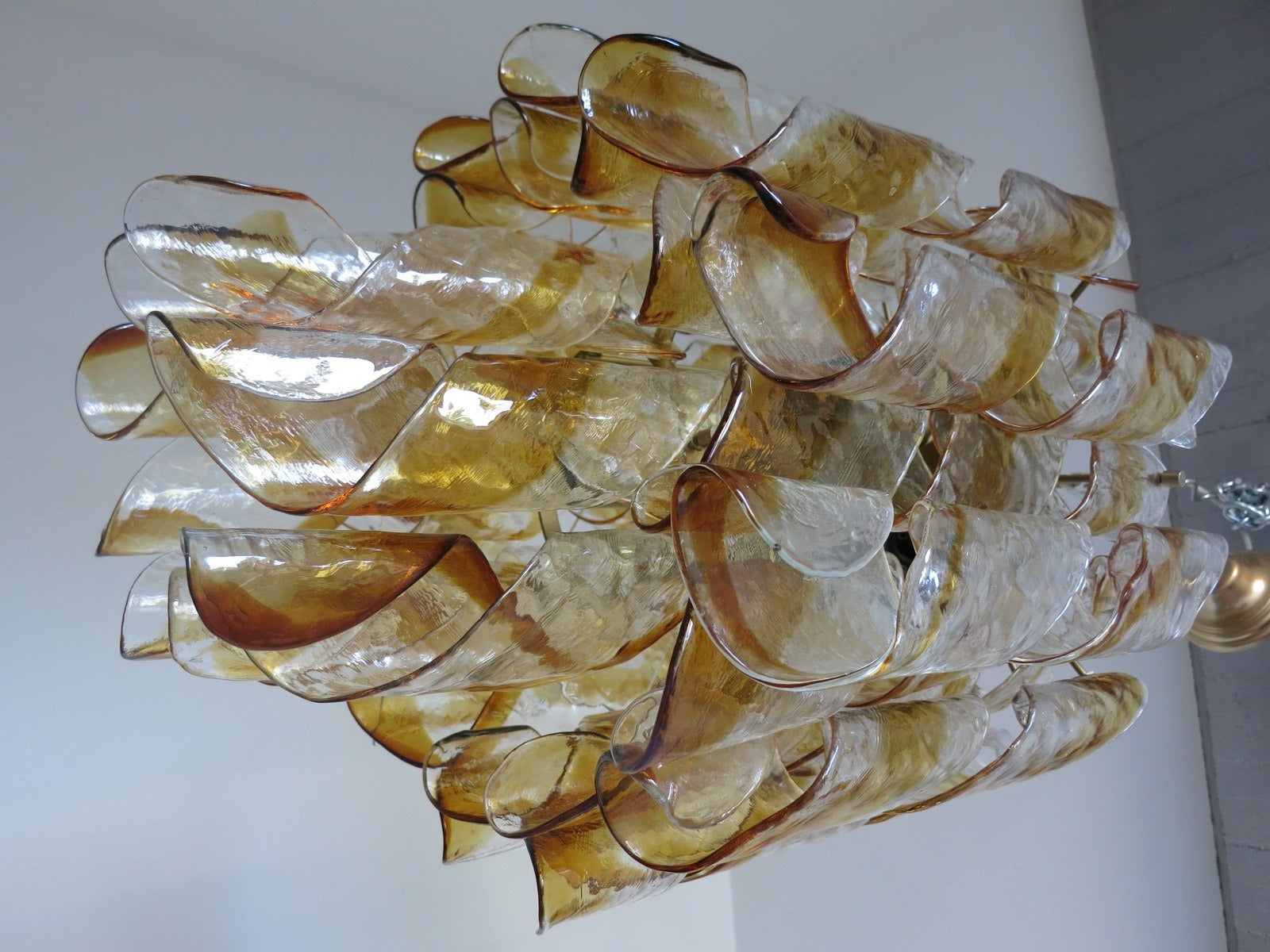 A Mazzega clear and amber twist Murano glass chandelier. The fixture has seven lights and a chrome frame. There is a total of 22 pieces of twisted Murano glass tubes. Measurements provided are for the fixture only (chain and canopy extra).