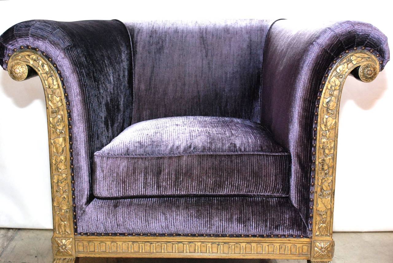 A wonderful pair of gilded club chairs upholstered in a purple Janet Yonaty fabric. Chairs have an excellently carved grape leaf design and claw feet.