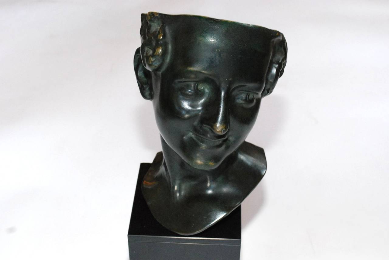 A vintage French bronze head sculpture on a black marble base. The back of the head is marked 