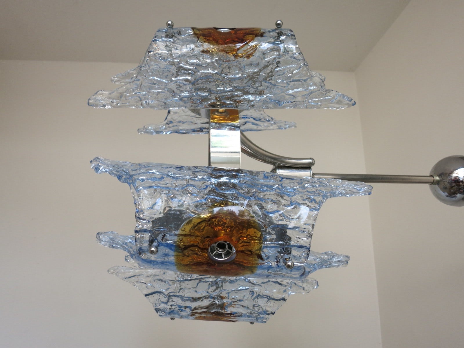 A Mazzega light blue and amber glass chandelier. Has a chrome frame and hold five lights. Height is to the top of the canopy.