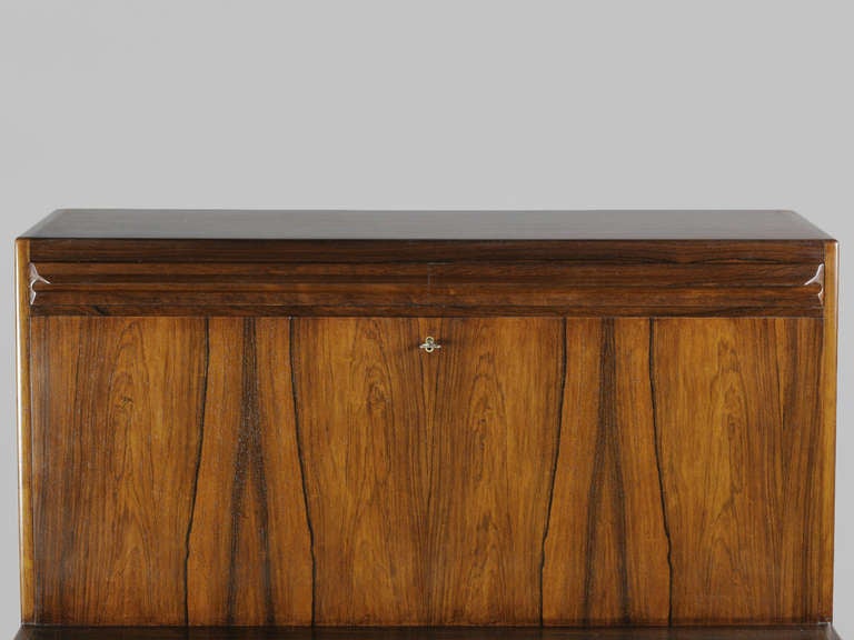 Elegant Danish Modern Rosewood Secretary with six drawers and fold down writing surface by Erling Torvits. Behind the fold down writing surface are storage compartments and drawers. The top rail conceals hidden drawers that have secret release