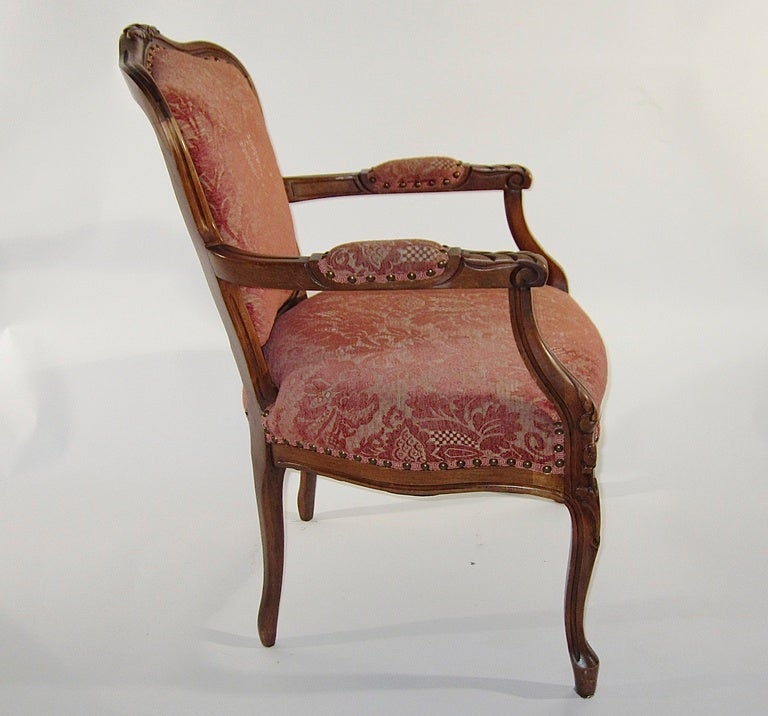 A most attractive and comfortable armchair with carved embellishments and a fine upholstered seating and arm rest.