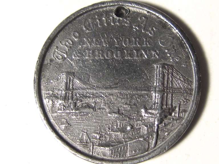 Commemorative opening day souvenir coin of the East River Bridge, known to us all as the Brooklyn Bridge. This 1883 white metal coin was circulated on the opening day, May 24, 1883 and is well detailed on the reverse side of the East River with all