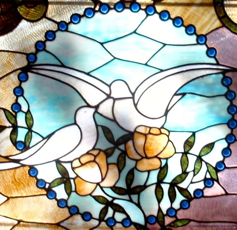 A fine specimen of a jeweled stained glass window panel made in the late 19th century. The theme of the dove, representing peace and love is encased in a oak frame  that is not original to the panel.
There are 164 jewels in this piece and the