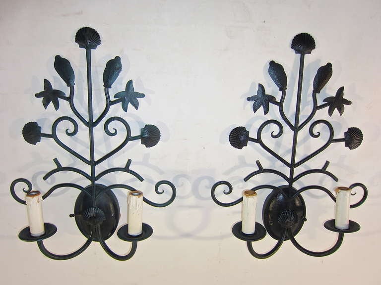 Iron Sconces with a marine theme of shells and starfish, finished in a dark green paint. These two light electrified candle style sconce are offered in pairs. The pair price is $ 1450 per pair. The pricing below represents the per each cost.