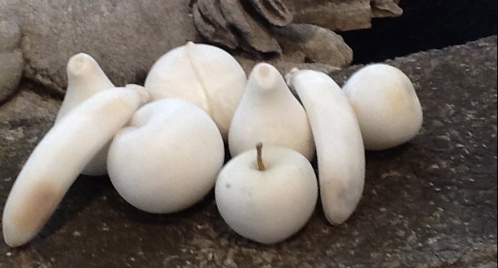 A group of eight carved fruits. Seven are white marble and one is alabaster.