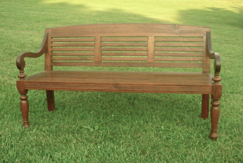 Teak bench with slatted seat and back, turned legs and reeded aprons. This bench with arms is perfect for home, garden rooms and patio areas. A deep seating area adds comfort .