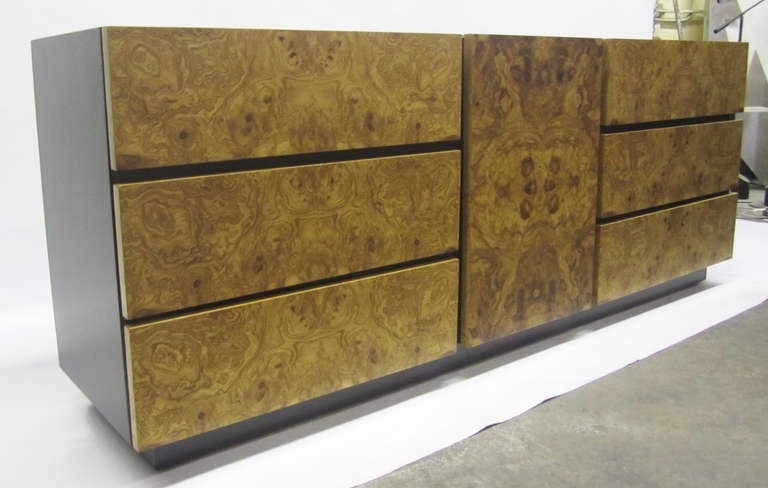 Sleek burl wood credenza featuring six pull-out drawers and three extra drawers concealed beneath a cabinet door. The body is ebonized walnut and the drawer fronts are olive burled wood.

Please contact showroom to find out about the matching