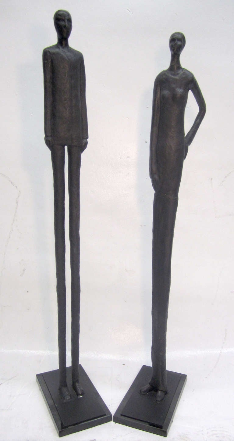 Ces saisissantes sculptures allongées en fonte représentant un couple atténué ont été clairement inspirées par l'œuvre du maître suisse Alberto Giacometti. Les œuvres reposent sur un socle en marbre noir. 
Les dimensions indiquées sont celles de