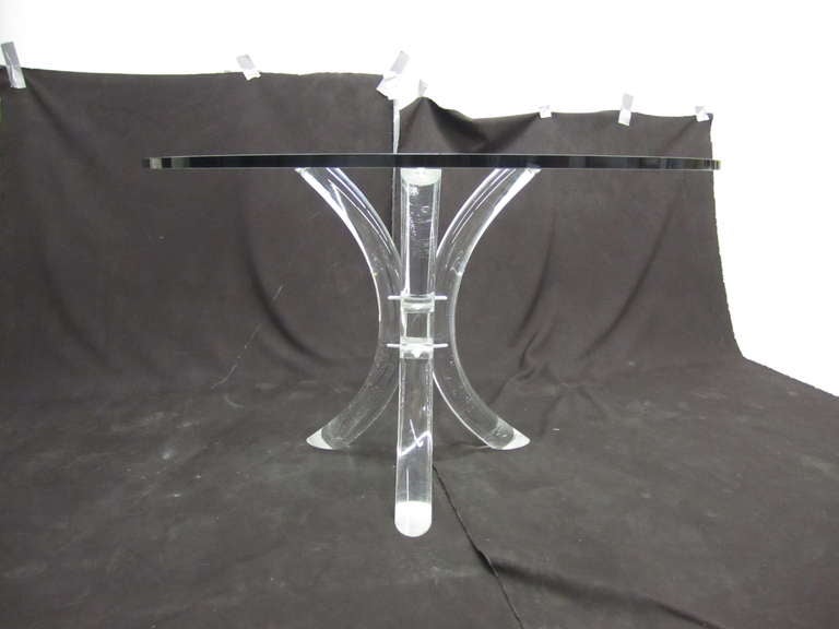 1970s lucite dining table by Charles Hollis Jones featuring three saber legs connected by a mirrored center and surmounted by a thick piece of glass.