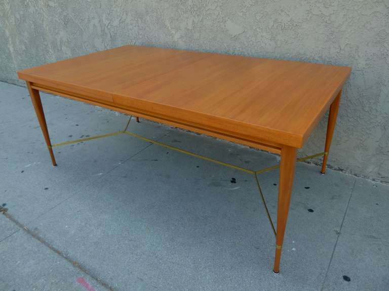 This elegant, mid-century dining table by Paul McCobb was designed for Calvin as part of the their Irvin collection.
It is made of blond mahogany with brass stretchers. Table retains the original makers mark and has 2 leaves that are 15
