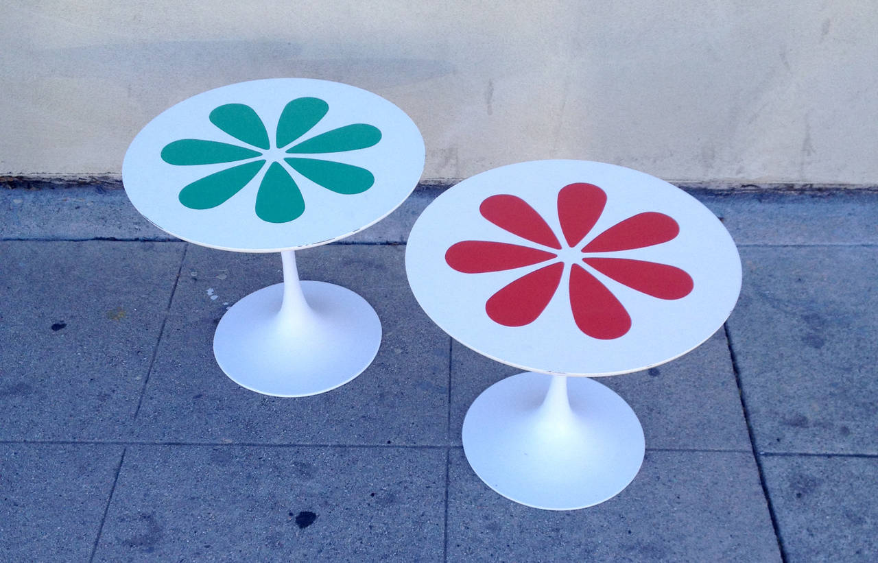 This set of Burke tulip tables inspired by Eero Saarinen features a retro flower motif in red and green. These side tables feature sturdy metal bases with a smooth laminated surface.